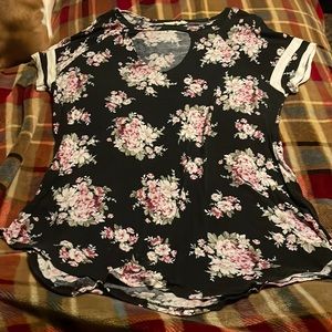 Black shirt with white stripes on the sleeve and pretty flowers around it